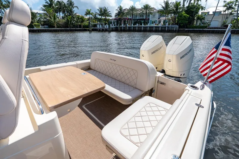 Slide: The Image of 2024 Chris-Craft Catalina 30 boat interior with seating, table, and dual Mercury engines. - 30