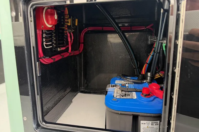 Slide: The Image of Electrical compartment of 2026 Chittum Skiffs 18 Laguna Madre Carbon with battery and wiring. - 19