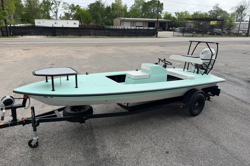 Slide: The Image of 2026 Chittum Skiffs 18 Laguna Madre Carbon boat on trailer, parked outdoors. - 4