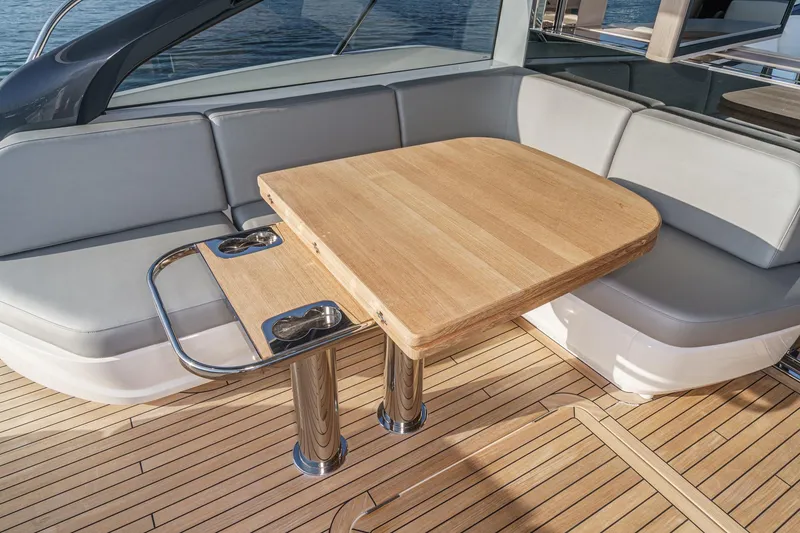 Slide: The Image of Luxurious seating area on 2026 Princess V55 yacht with wooden table and cup holders. - 23