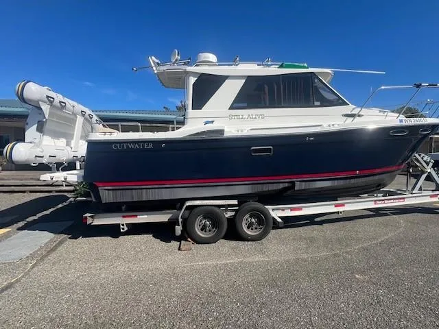 The Image of 2016 Cutwater 26 boat on trailer under clear blue sky. - 0