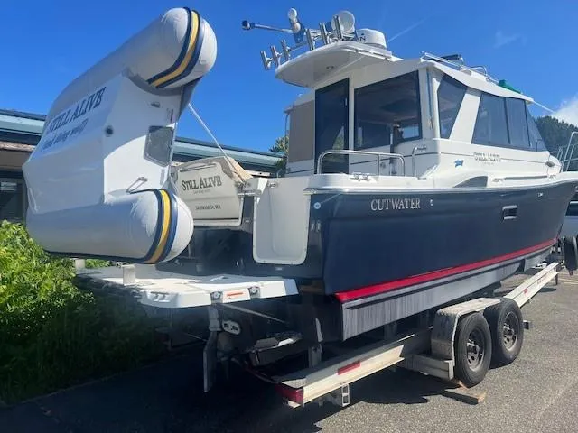 Slide: The Image of 2016 Cutwater 26 boat on trailer with inflatable dinghy, parked outdoors. - 1
