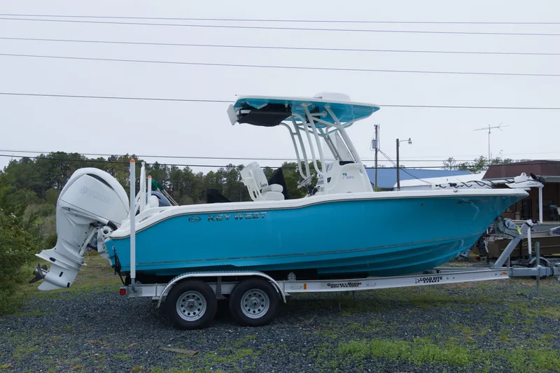 The Image of 2025 Key West 239 FS boat on trailer, vibrant blue hull, parked outdoors. - 0