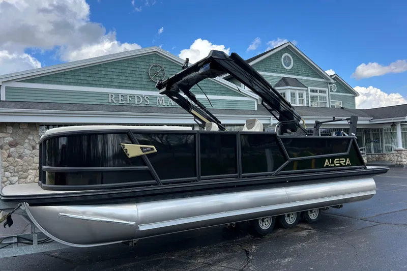 The Image of Alera M23L 2026 pontoon boat displayed outside Reed's Marine building. - 1