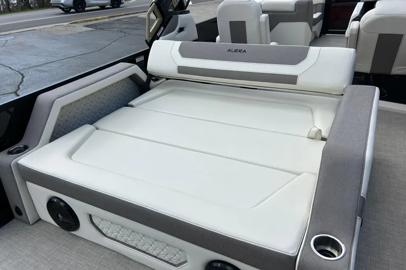 Slide: The Image of 2026 Alera M23L boat interior with white and gray seating, cup holders, and speaker. - 16