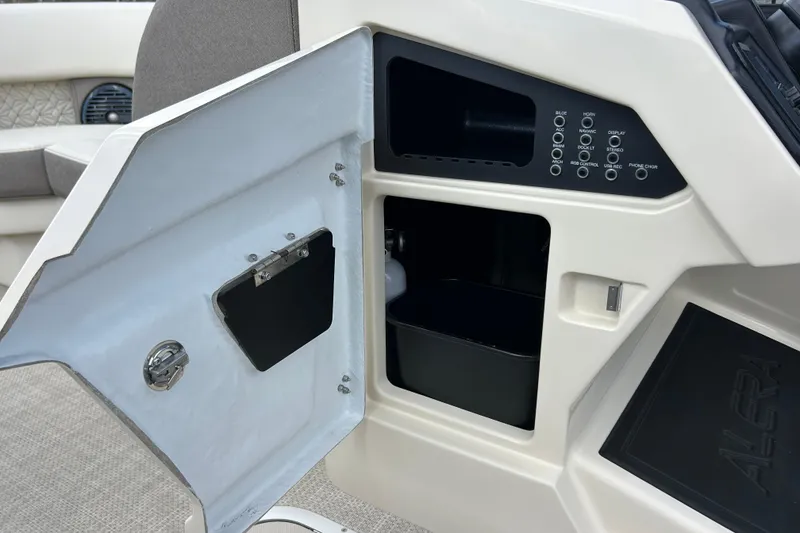 Slide: The Image of Open storage compartment on Alera M23L boat, showcasing control panel and seating, 2026 model. - 25