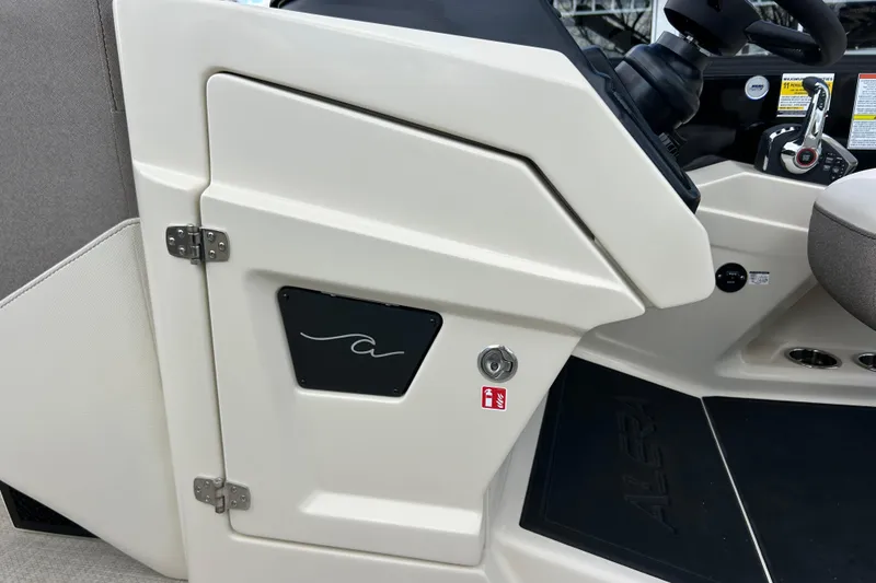 Slide: The Image of 2026 Alera M23L boat interior with steering console and storage compartment. - 26
