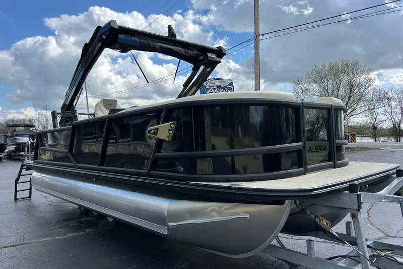 Slide: The Image of 2026 Alera M23L pontoon boat on trailer under cloudy sky. - 4