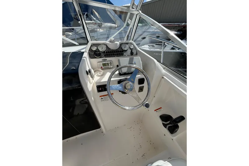 Slide: The Image of 2005 Aquasport 250 Explorer boat helm with steering wheel and instrument panel. - 10