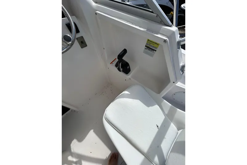 Slide: The Image of Interior view of a 2005 Aquasport 250 Explorer boat cockpit with steering wheel and seat. - 13