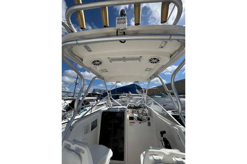 Slide: The Image of 2005 Aquasport 250 Explorer boat interior with steering wheel and overhead rod holders. - 15