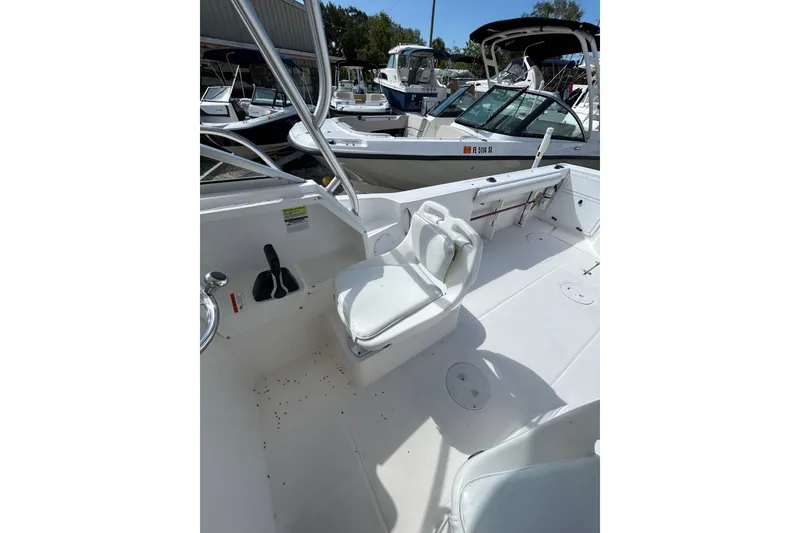 Slide: The Image of 2005 Aquasport 250 Explorer boat interior with white seating and control panel. - 9