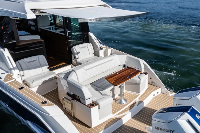 Slide: The Image of 2026 Tiara Yachts 43LE luxury boat with elegant seating and wooden table on deck. - 18
