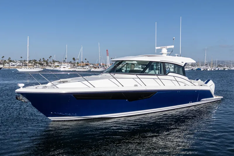 Slide: The Image of 2026 Tiara Yachts 43LE luxury boat on calm water, with marina in background. - 2