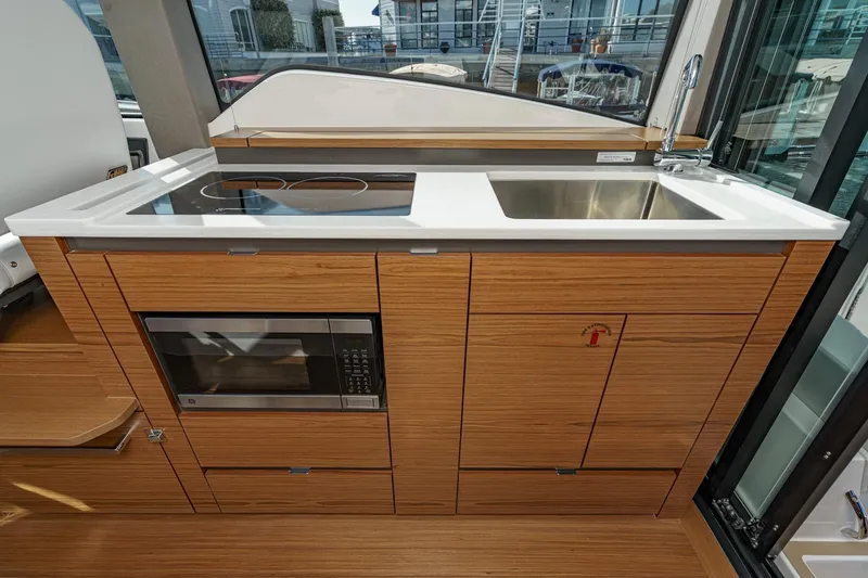 Slide: The Image of Modern kitchen area in 2026 Tiara Yachts 43LE with stove, sink, and microwave. - 35