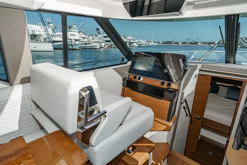 Slide: The Image of Interior of 2026 Tiara Yachts 43LE, featuring helm station and cabin view. - 41