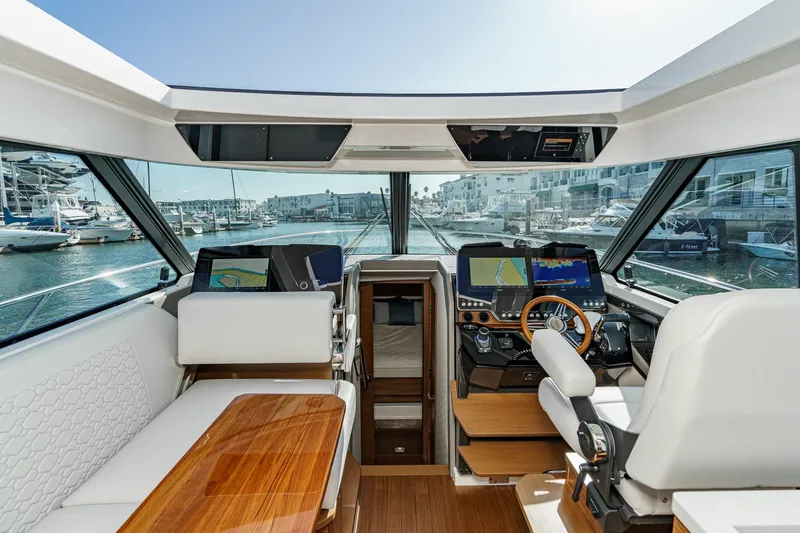 Slide: The Image of Interior view of 2026 Tiara Yachts 43LE, featuring modern navigation equipment and luxurious seating. - 43