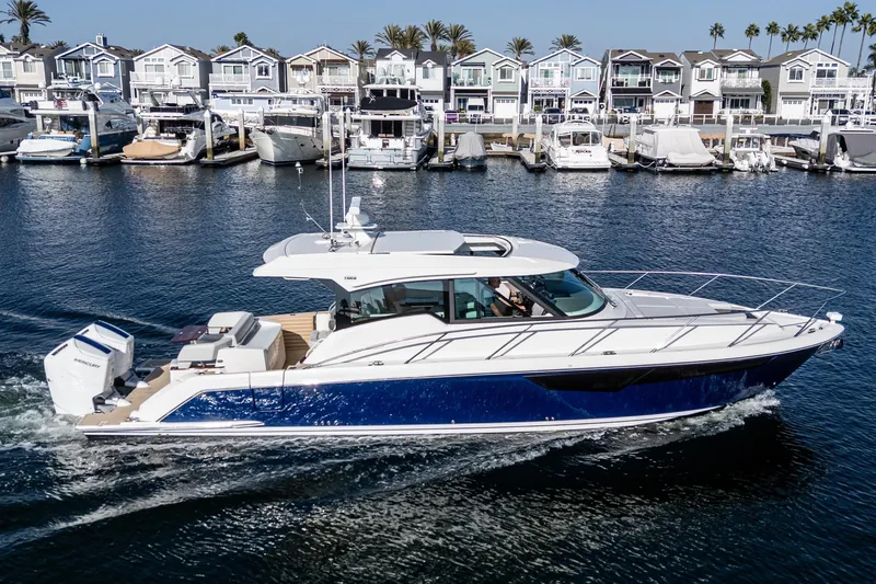 Slide: The Image of 2026 Tiara Yachts 43LE cruising in a marina with waterfront homes in the background. - 6