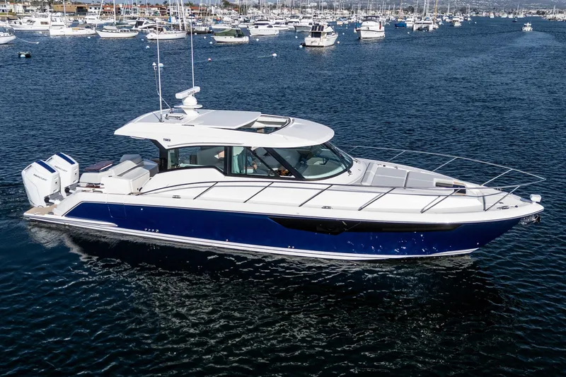 Slide: The Image of 2026 Tiara Yachts 43LE cruising in a marina, showcasing sleek design and powerful engines. - 9
