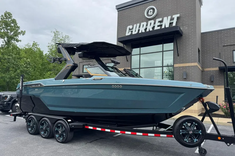 The Image of 2025 MasterCraft XStar 25 boat on trailer outside dealership, showcasing sleek design. - 1