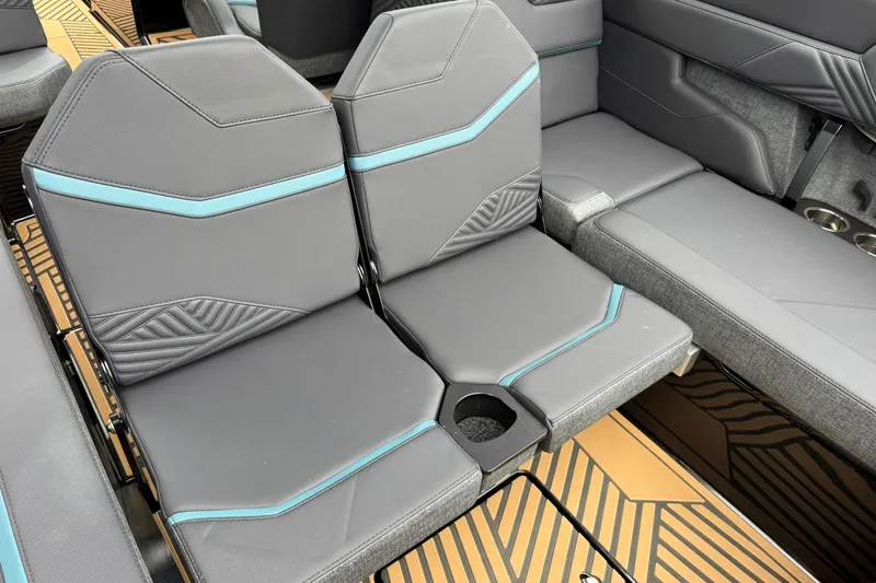Slide: The Image of 2025 MasterCraft XStar 25 boat interior with gray and teal seating, featuring a cup holder. - 21