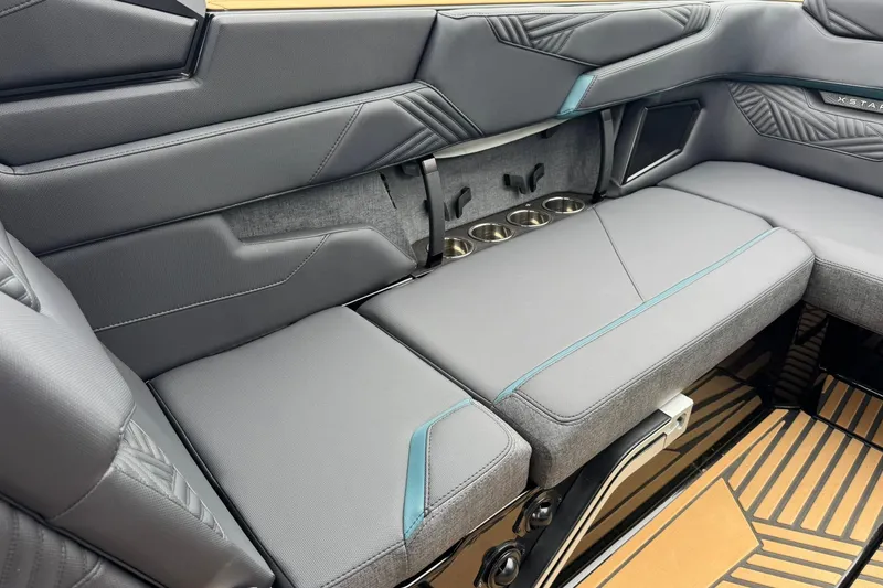 Slide: The Image of 2025 MasterCraft XStar 25 interior with sleek gray seating and integrated cup holders. - 24