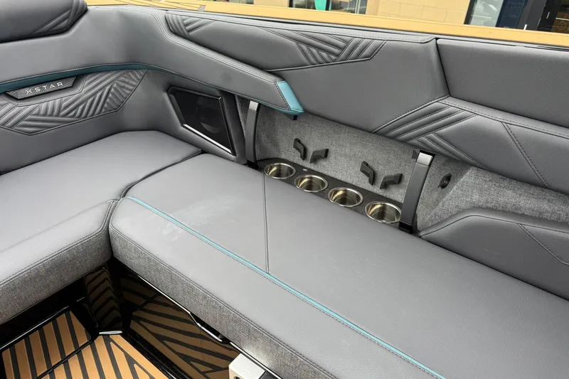 Slide: The Image of 2025 MasterCraft XStar 25 interior seating with cup holders and stylish upholstery. - 25