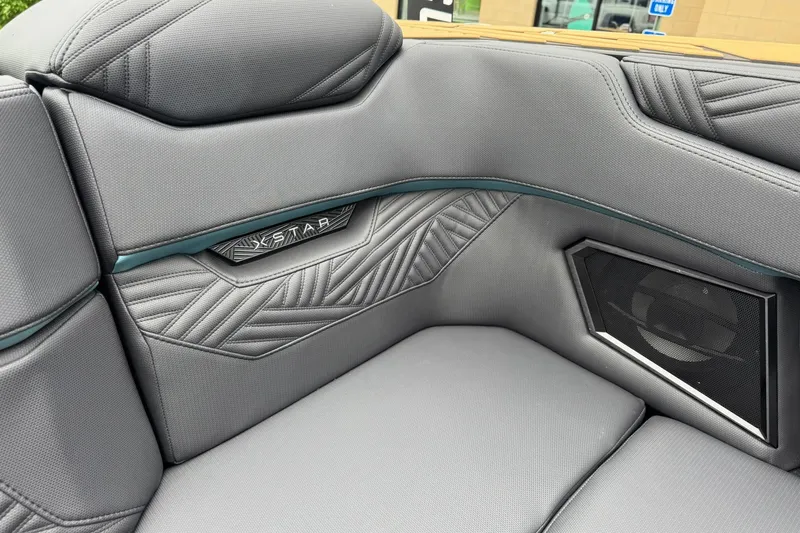 Slide: The Image of 2025 MasterCraft XStar 25 interior with sleek gray upholstery and integrated speaker system. - 26