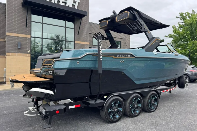 Slide: The Image of 2025 MasterCraft XStar 25 boat on trailer, parked outside a modern building. - 4