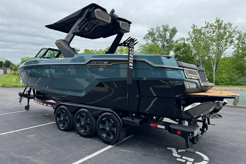 Slide: The Image of 2025 MasterCraft XStar 25 boat on trailer, sleek design, parked outdoors. - 8