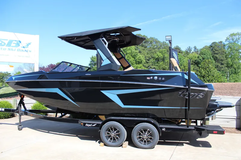 Slide: The Image of 2026 Tigé 22RZX boat on trailer, sleek black design with blue accents. - 3