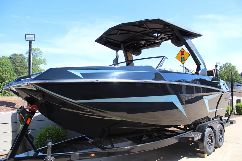 Slide: The Image of 2026 Tigé 22RZX boat on trailer, sleek black design, parked outdoors. - 5