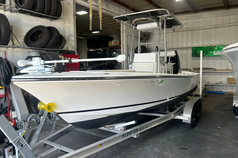 The Image of 2005 SeaCraft SC 23 Classic boat on trailer in garage with tires. - 0