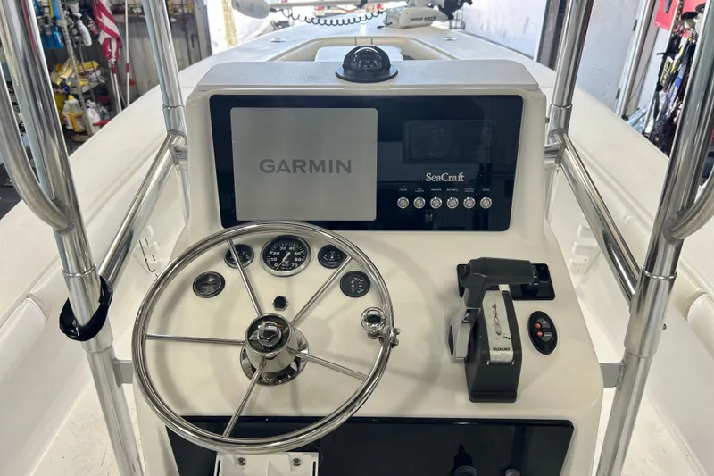 Slide: The Image of 2005 SeaCraft SC 23 Classic boat dashboard with Garmin navigation system and steering wheel. - 2