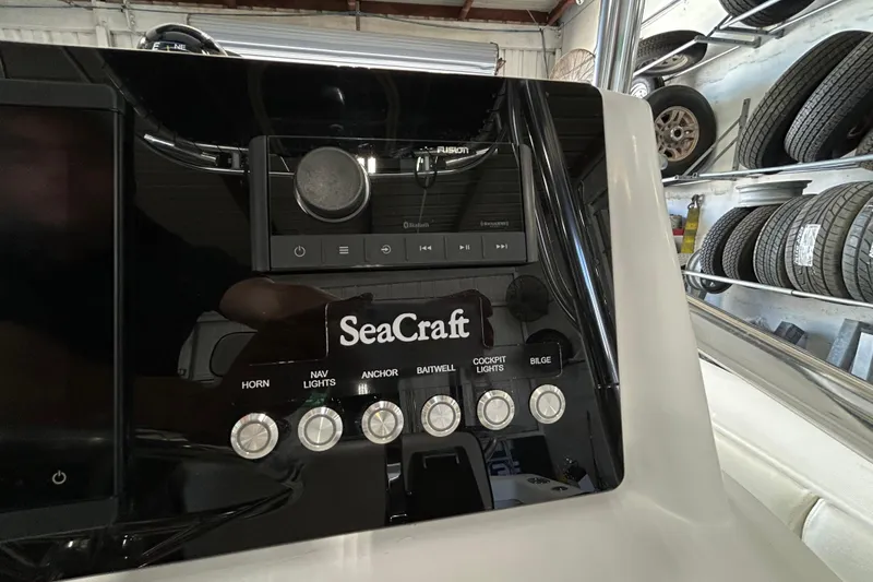 Slide: The Image of Control panel of a 2005 SeaCraft SC 23 Classic boat with various switches and audio controls. - 5