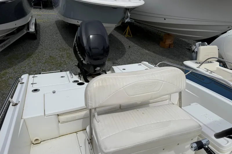 Slide: The Image of 2011 Boston Whaler 180 Dauntless boat with outboard motor and seating, docked on gravel. - 6