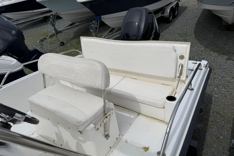 Slide: The Image of 2011 Boston Whaler 180 Dauntless boat interior with white seating and motor. - 7
