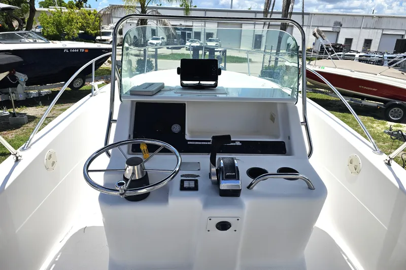 Slide: The Image of 1998 Bayliner 2503 Trophy Center Console boat dashboard with steering wheel and controls. - 10