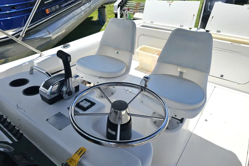Slide: The Image of 1998 Bayliner 2503 Trophy Center Console boat interior with steering wheel and dual seats. - 11