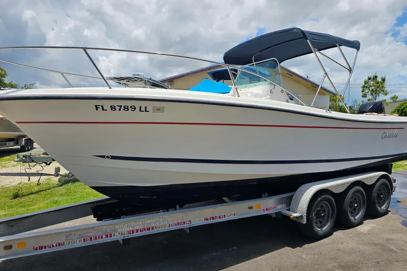 Slide: The Image of 1998 Bayliner 2503 Trophy Center Console boat on a trailer, under a cloudy sky. - 2