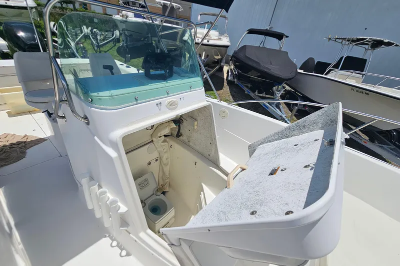 Slide: The Image of 1998 Bayliner 2503 Trophy Center Console boat with open storage compartment and windshield. - 22