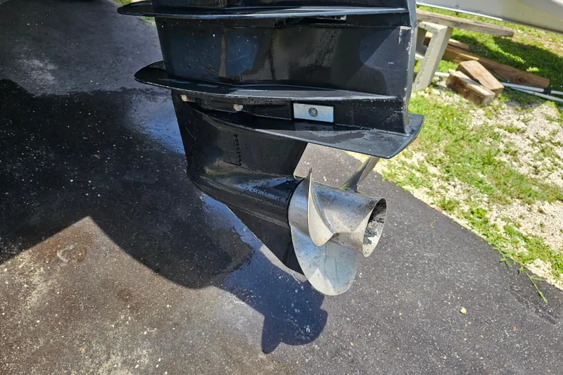 Slide: The Image of Propeller of a 1998 Bayliner 2503 Trophy Center Console boat on wet pavement. - 6