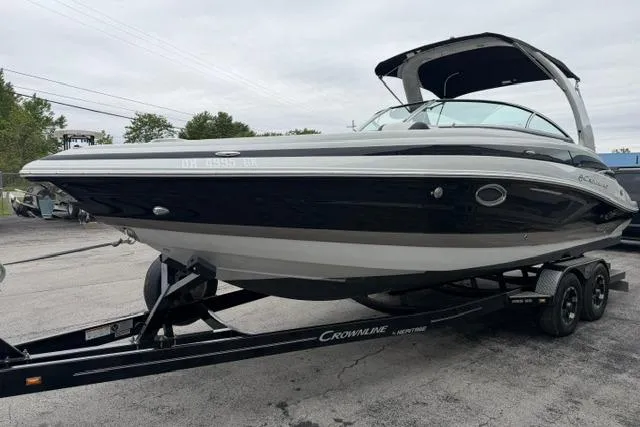 Slide: The Image of 2022 Crownline 265 SS boat on trailer, black and white exterior, parked outdoors. - 3