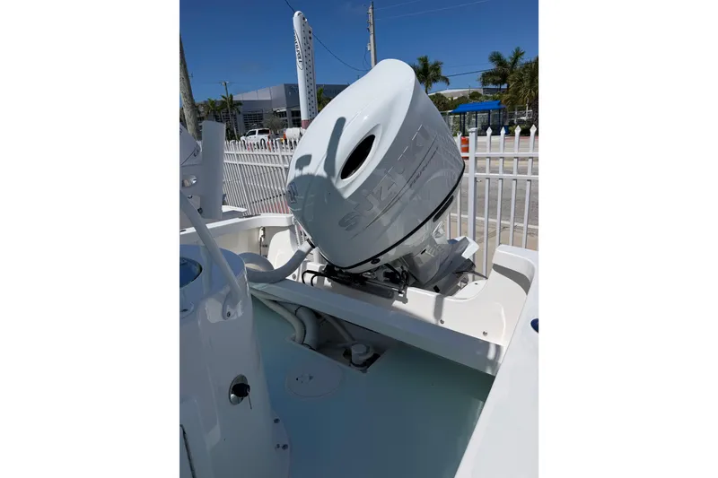 Slide: The Image of 2014 Albury Brothers 20 boat with Suzuki outboard motor, parked near a white fence. - 10