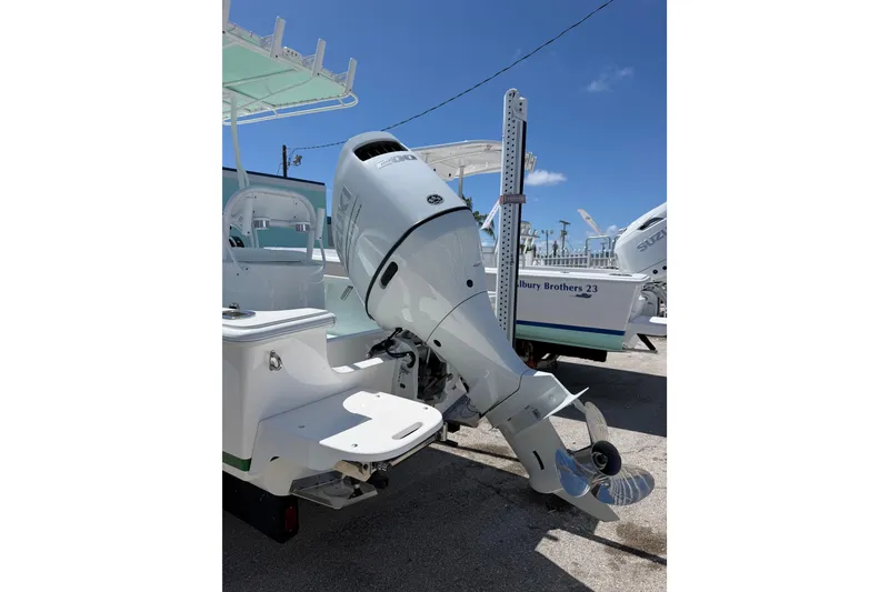 Slide: The Image of 2014 Albury Brothers 20 boat with outboard motor, displayed outdoors under clear blue sky. - 3