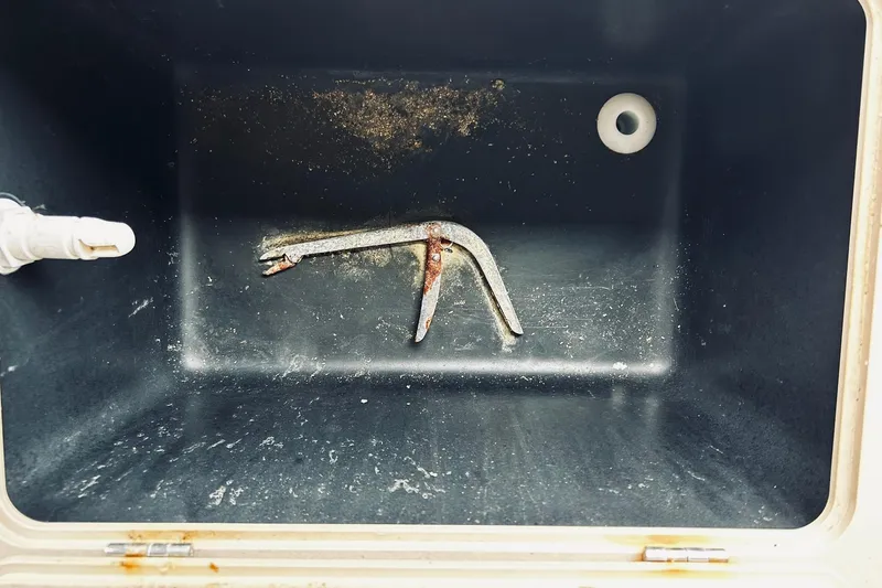 Slide: The Image of Empty storage compartment with a rusted tool inside Avalon LSZ Rear Fish 2021 boat. - 16