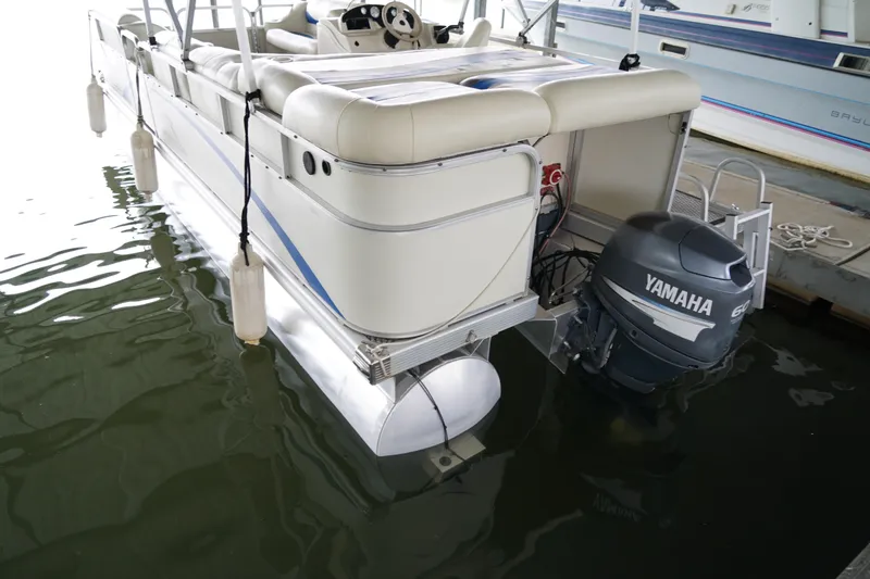 Slide: The Image of 2005 Bennington II 207L pontoon boat with Yamaha outboard motor docked in water. - 11