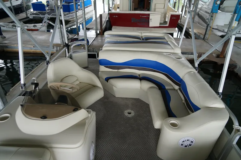 Slide: The Image of 2005 Bennington II 207L pontoon boat with beige and blue seating at a marina. - 7