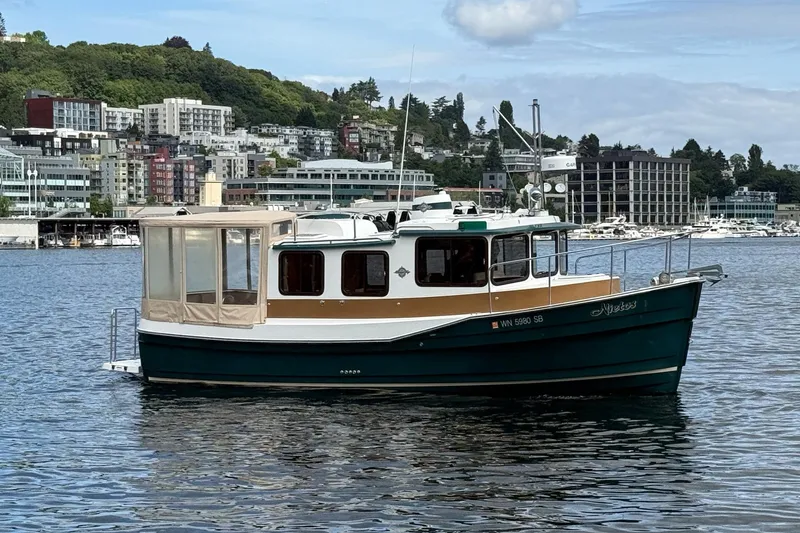 Slide: The Image of 2014 Ranger Tugs R-27 boat on water with cityscape background. - 15