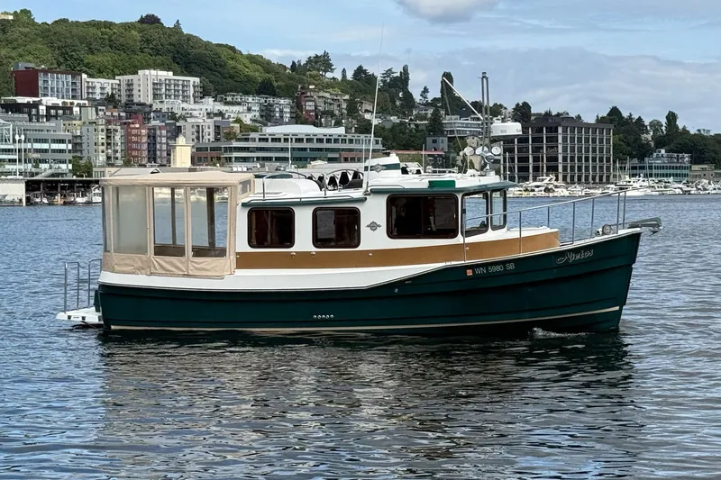 Slide: The Image of 2014 Ranger Tugs R-27 boat on water with cityscape background. - 16